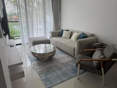 a living room with a couch and a coffee table at Cassia residences Phuket in Laguna Phuket