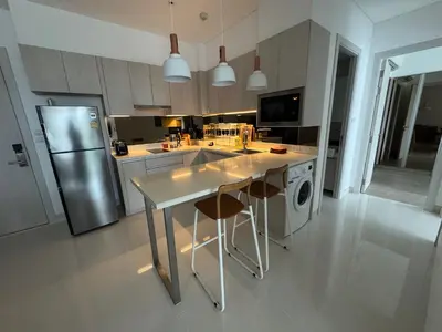 a kitchen with a stainless steel refrigerator and a table at Cassia residences Phuket in Laguna Phuket