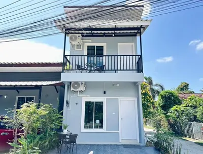 a white house with a balcony and a porch at Sachi House Stay Near Muay Thai Gym and Beach in Ban Thalat Choeng Thale