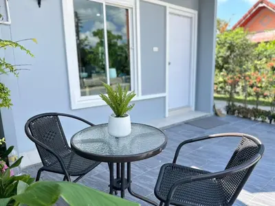 a table and chairs on a patio with a potted plant at Sachi House Stay Near Muay Thai Gym and Beach in Ban Thalat Choeng Thale
