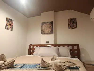a bedroom with a bed and two pictures on the wall at Hop guest House in Patong Beach