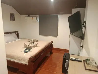 a room with a bed with a teddy bear sitting on it at Hop guest House in Patong Beach