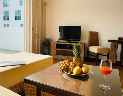 a living room with a table with a bowl of fruit and a wine glass at Kata Ocean View 1 bedroom Sea View 71 m2 in Kata Beach