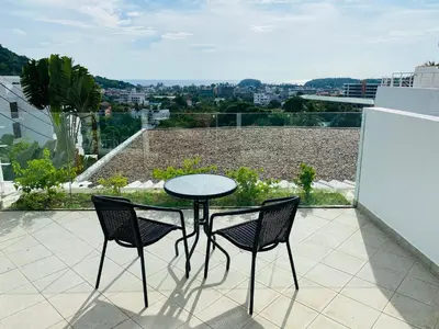 a table and two chairs sitting on a balcony at Kata Ocean View 1 bedroom Sea View 71 m2 in Kata Beach