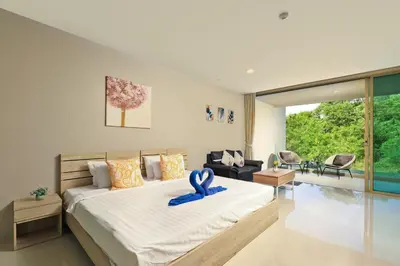 a bedroom with a large bed with a blue ribbon on it at Spacious studio near Karon beach by Pro ARK-204 in Phuket Town