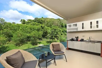 an open living room with a view of a garden at Spacious studio near Karon beach by Pro ARK-204 in Phuket Town
