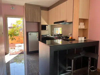 a kitchen with a black counter and a refrigerator at 2 Bedroom Pool Villa in Ban Na Bon