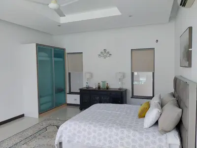 a white bedroom with a bed and a dresser at Villa Destiny AZ in Ban Saiyuan (1)