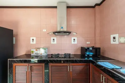a kitchen with a black counter top and pink tiles at V155 4BR Large Family Villa Chalong in Chalong