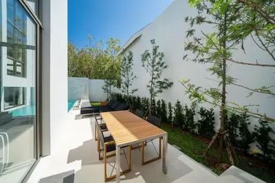 an outdoor patio with a wooden table and chairs at Exclusive New Build - Designer 3BR Pool Villa in Prestigious LuxPride 4 L7 Residence in Bang Tao Beach