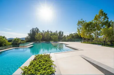 a swimming pool with blue water and trees at Laguna Beachside residences apartamens, walking distance to the sea in Bang Tao Beach