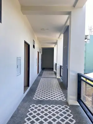 a hallway with white walls and a tile floor at Sleep At Airport in Nai Yang Beach