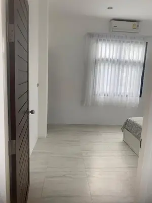 a white room with a bed and a window at Phuket Mali house in Ban Sam Kong