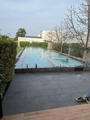 a person swimming in a large swimming pool at Phuket Mali house in Ban Sam Kong