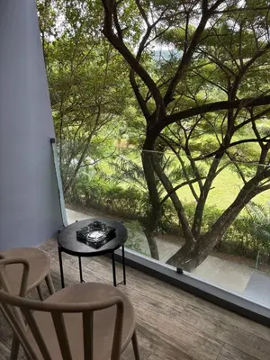 a table and chairs on a balcony with a large window at Citygate Kamala Condo Paris in Kamala Beach