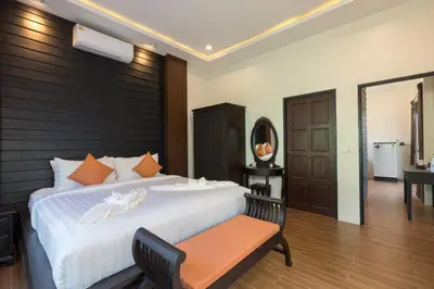 a bedroom with a large bed with a wooden headboard at Blue Palm Residence Kata in Kata Beach