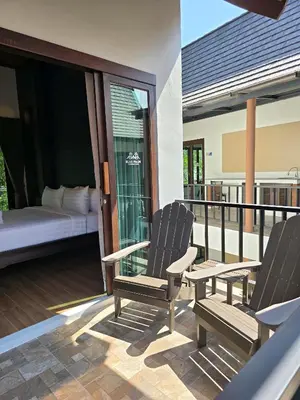two chairs sitting on a balcony with a bed at Blue Palm Residence Kata in Kata Beach