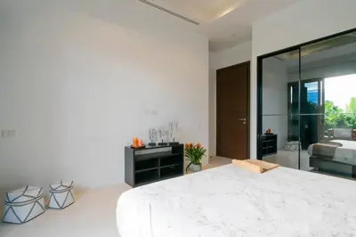 a white bedroom with a large bed and a mirror at Seaview Villa Near Naithon Beach Phuket in Nai Thon Beach