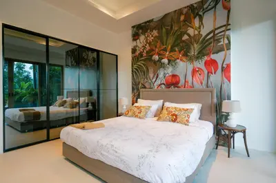a bedroom with a large bed with a painting on the wall at Seaview Villa Near Naithon Beach Phuket in Nai Thon Beach