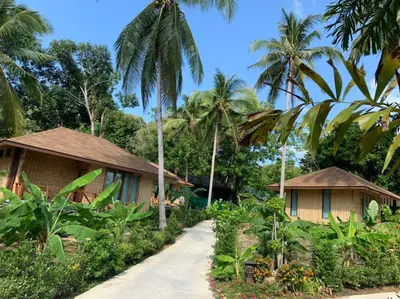 a resort with palm trees and a pathway at Thiwson Beach Resort - SHA Extra Plus in Ko Yao Yai