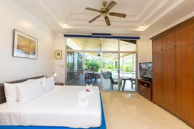 a bedroom with a bed and a ceiling fan at Villa Valentine Phuket in Ban Thalat Choeng Thale