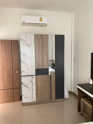 a bedroom with a large mirror in a room at Mali Villa in Ban Suan