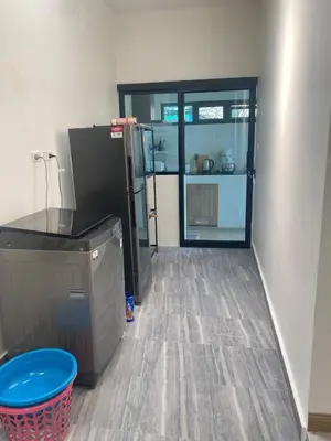 a kitchen with a refrigerator and a trash can in a room at Mali Villa in Ban Suan
