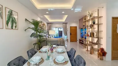 a dining room with a table and blue chairs at Cozy family townhouse in Chalong