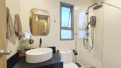 a bathroom with a toilet and a sink and a shower at Cozy family townhouse in Chalong