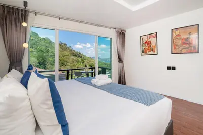 a bedroom with a large bed and a large window at Patong Cliff Pool villa in Patong Beach