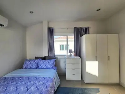 a bedroom with a bed and a dresser and a window at Sirihouse at Supalai Bella Thalang Phuket in Phuket