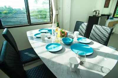 a dining room table with blue dishes on it at Songbird Suites - Deluxe 2 Bedroom, 2 Bathroom Apt in Ban Khlong Haeng