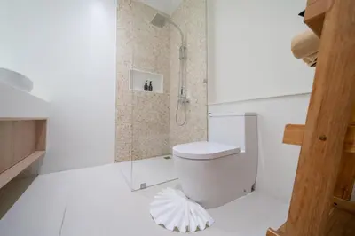 a white bathroom with a toilet and a shower at Coco Villas Phuket - Private Pool Villas by Escape Villas in Thalang