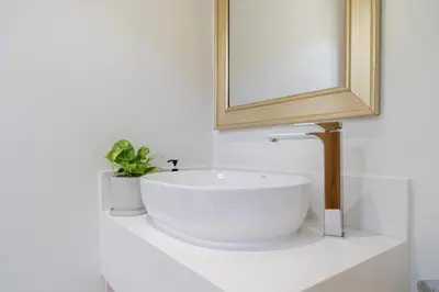 a bathroom with a white sink and a mirror at Coco Villas Phuket - Private Pool Villas by Escape Villas in Thalang