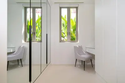 a room with two chairs and a table and two windows at Coco Villas Phuket - Private Pool Villas by Escape Villas in Thalang