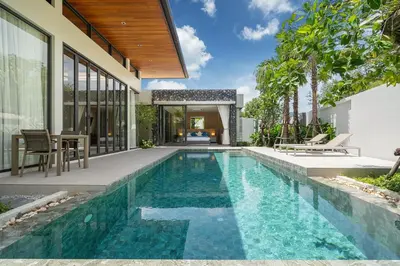 an infinity pool in the backyard of a house at Bang Tao Botanica Modern Loft 3 bd in Ban Pak Lak