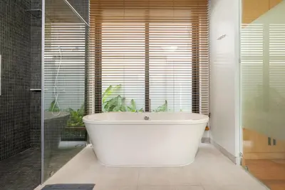 a white bath tub in a bathroom with a window at Bang Tao Botanica Modern Loft 4 bd S in Phuket