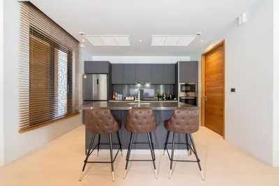 a kitchen with a counter and two bar stools at Bang Tao Botanica Modern Loft 4 bd S in Phuket
