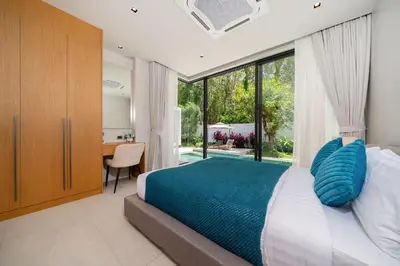 a bedroom with a large bed and a desk at Bang Tao Botanica Modern Loft 4 bd S in Phuket