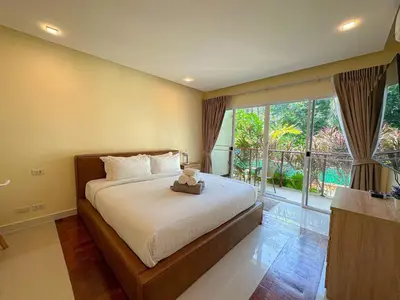 a bedroom with a bed with a teddy bear on it at Oasis 1 Bedroom Apartment In Rawai in Phuket Town