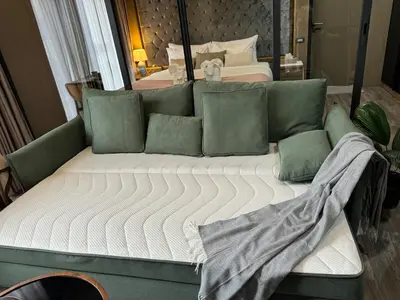 a bed with green pillows in a bedroom at Patong rooftop Pool luxury Condo with Bathtub and sofa bed big balcony in Patong Beach