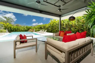 a patio with a couch and a table and a pool at Luxurious 5BR Villa Mayacol with 17m Long Pool, NaiHarn in Rawai Beach