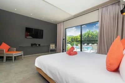 a bedroom with a large bed and a large window at Luxurious 5BR Villa Mayacol with 17m Long Pool, NaiHarn in Rawai Beach