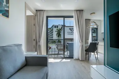 a living room with a couch and a view of a kitchen at Palmetto Park Residence in Karon Beach