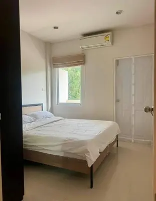 a bedroom with a large bed with a window at Дом у биг Будды in Ban Klang