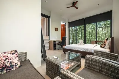 a bedroom with a bed and a living room at V158 9BR Tennis On prestigious Phuket Country Club in Kathu