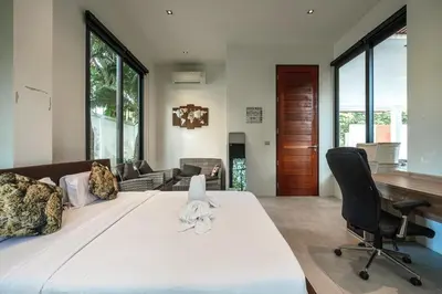 a bedroom with a large bed with a desk and chairs at V158 9BR Tennis On prestigious Phuket Country Club in Kathu
