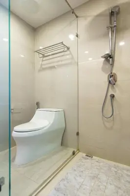 a bathroom with a toilet and a glass shower stall at Lovely studio 5 stars Hotel La Vita in Phuket Town