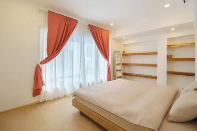 a bedroom with a bed and a large window at 4BR Pool Villa Sukhum in Phuket Town in Changwat Phuket