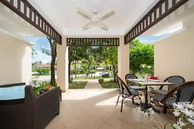 a patio with a table and chairs and a ceiling fan at Angsana Laguna Phuket 2- bedroom, with pool access in Layan Beach